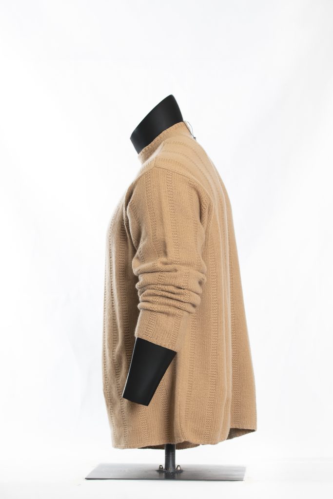 Side view of camel textured roll-neck sweater on black mannequin
